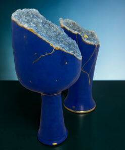 Blue ceramic vase edge split open to reveal sparkling blue crystals and gold veins along the rim.