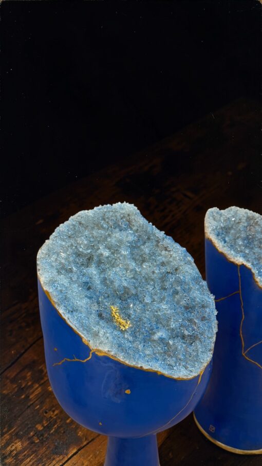 IMG_0800 | Kintsugi by Myriam GREFF Blue ceramic vases topped with rough blue crystal geode halves, placed on a wooden surface.