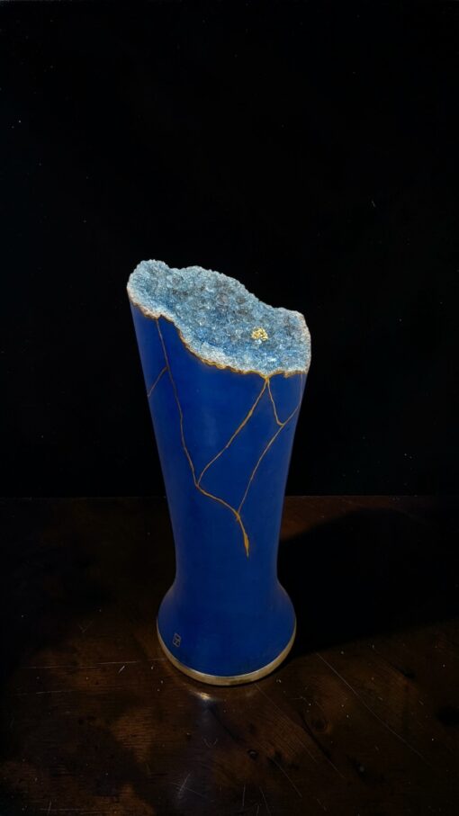 IMG_0805 | Kintsugi by Myriam GREFF Blue ceramic vase with a jagged blue geode top rim and gold vein cracks running down the sides.
