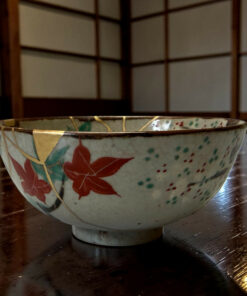 Close-up of a ceramic bowl with colorful floral pattern resting on a dark wooden table.