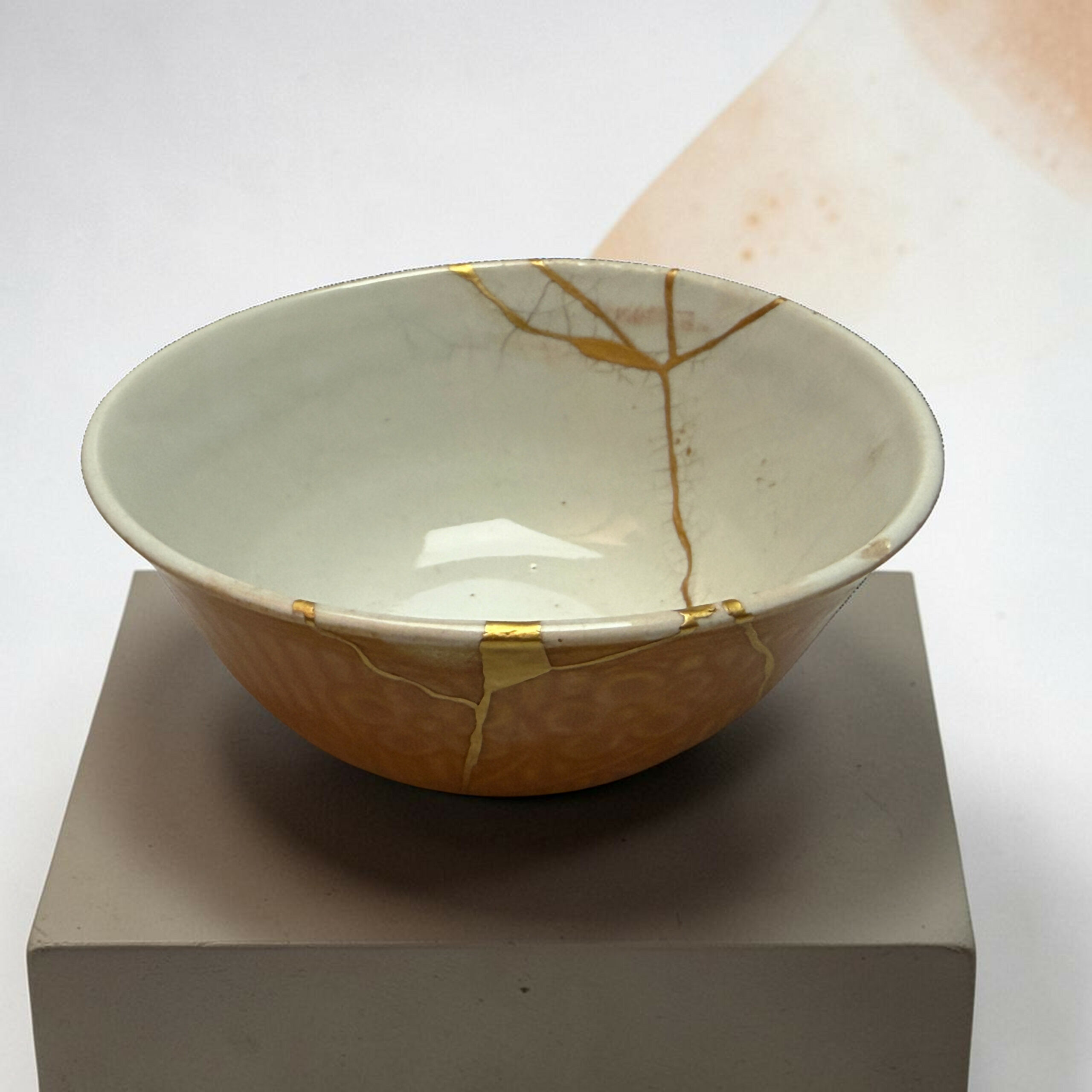 IMG_2503-Photoroom | Kintsugi by Myriam GREFF White ceramic bowl with a gold crackle glaze pattern, placed on a display pedestal in a neutral setting