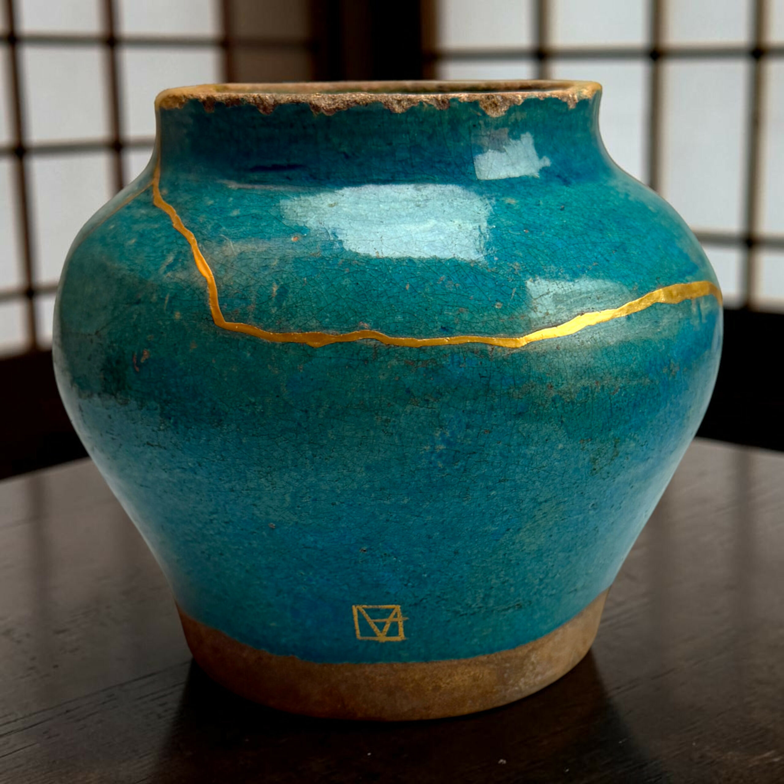 IMG_2516-Photoroom | Kintsugi by Myriam GREFF Close-up of a turquoise ceramic vase with a chipped rim and gold crackle lines.