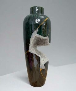 Tall glazed ceramic vase with a jagged white crystalline fracture running down its side