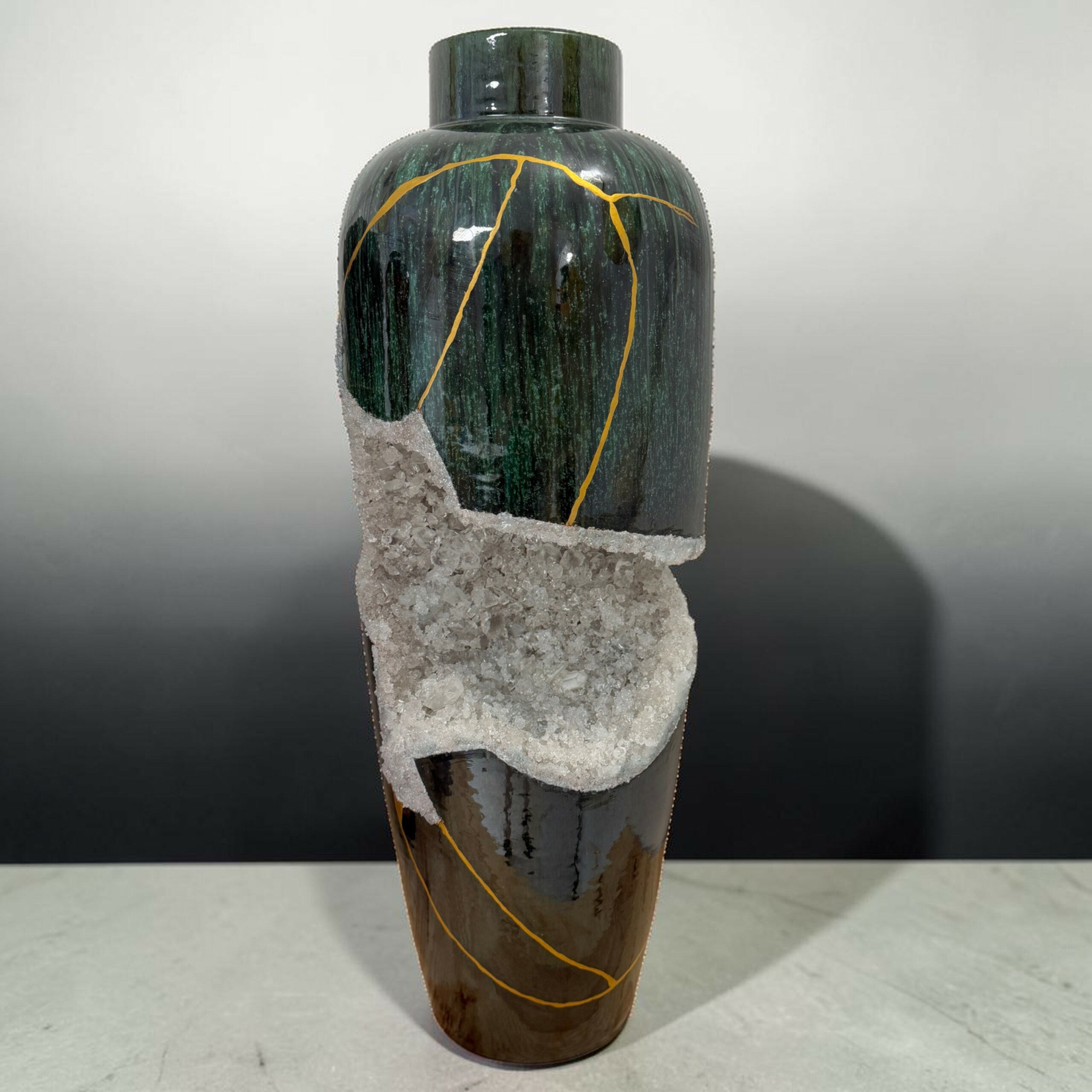 2clarte-souterraine-vase-geode-vert-blanc-myriam-greffjpg | Kintsugi by Myriam GREFF Dark green bottle wrapped in salt crystals with a yellow string, set against a neutral gray background.