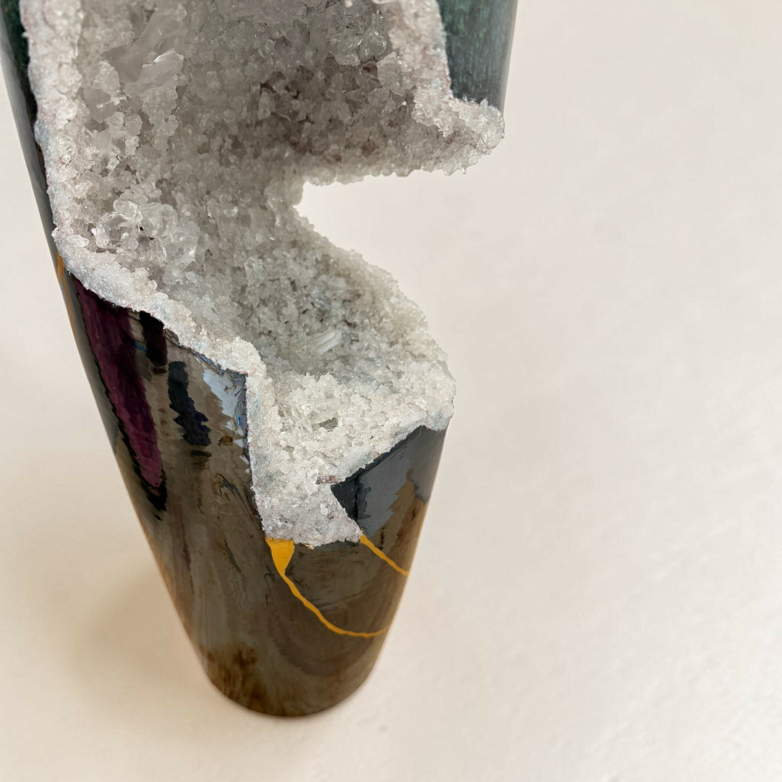 4clarte-souterraine-vase-geode-vert-blanc-myriam-greffjpg | Kintsugi by Myriam GREFF Close-up of a dark, glossy ceramic vase with a rough white crystal crust along its edge.