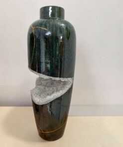 Tall glossy dark green vase with a white crystalline band around its midsection, set against a light background.