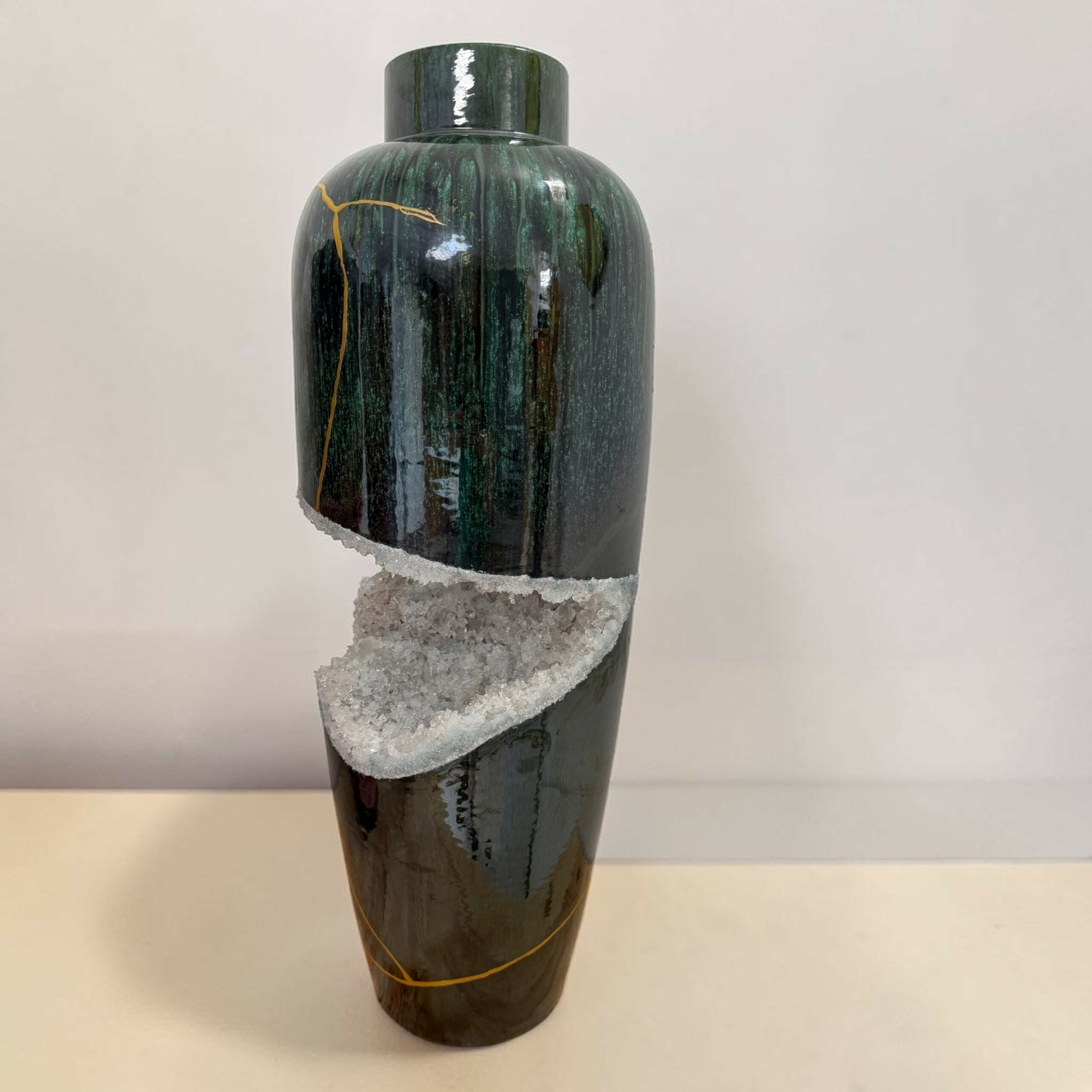 5clarte-souterraine-vase-geode-vert-blanc-myriam-greffjpg | Kintsugi by Myriam GREFF Tall glossy dark green vase with a white crystalline band around its midsection, set against a light background.