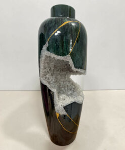Tall vertical green stone sculpture with gold veining and a crystalline mineral crust along the lower half.