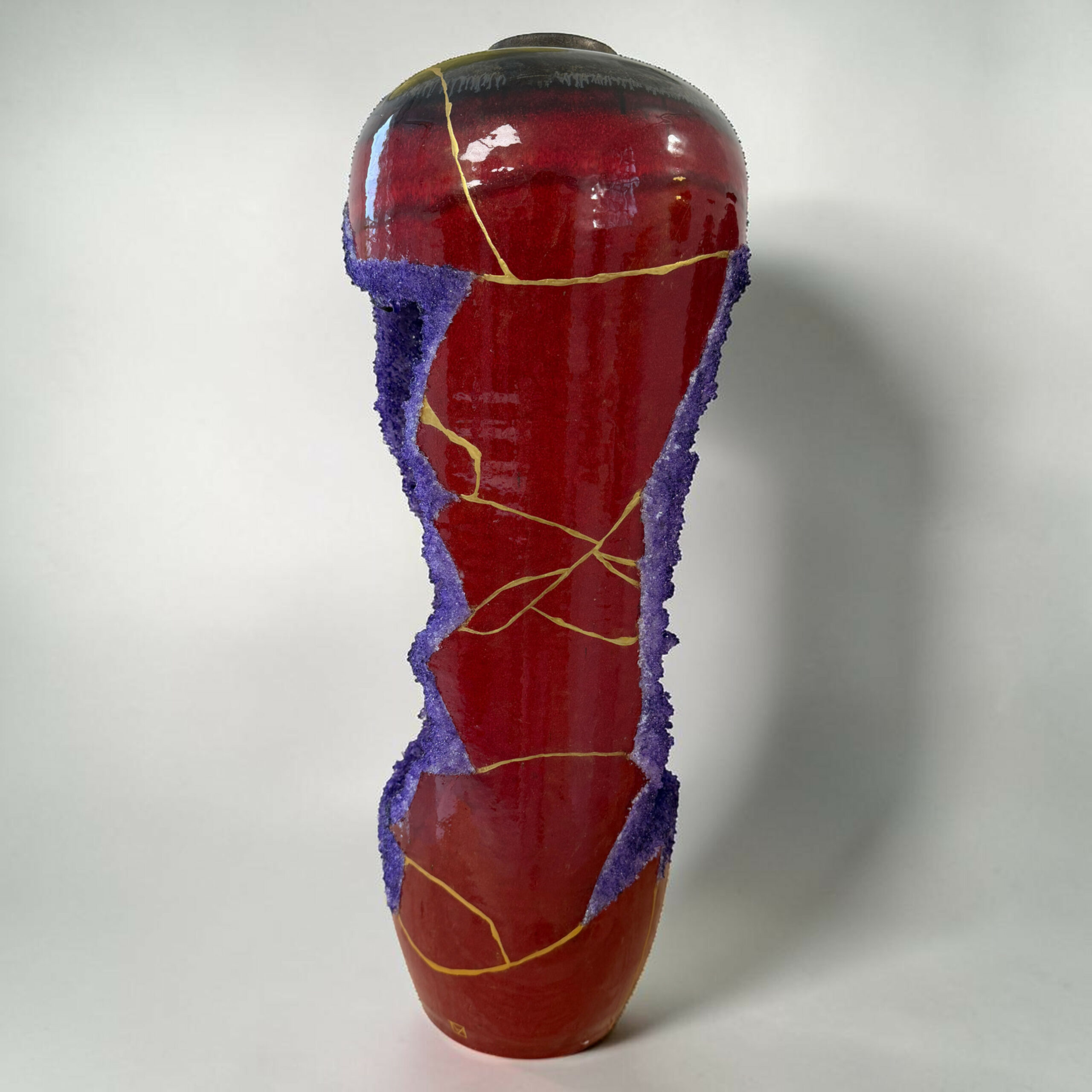 IMG_3237-Photoroom | Kintsugi by Myriam GREFF Close-up of a red popsicle with a purple sugar-coated rim and yellow cracks, against a white background.